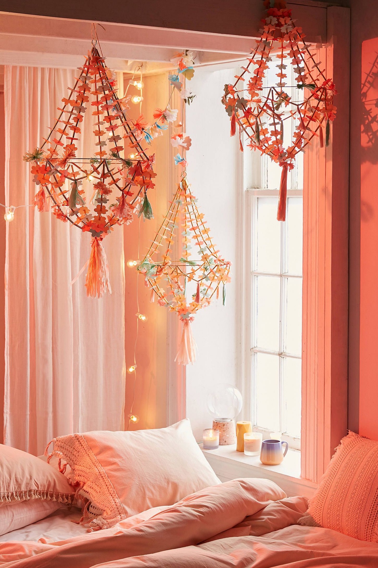 Três candelabros decorativos suspensos acima de uma cama num quarto acolhedor