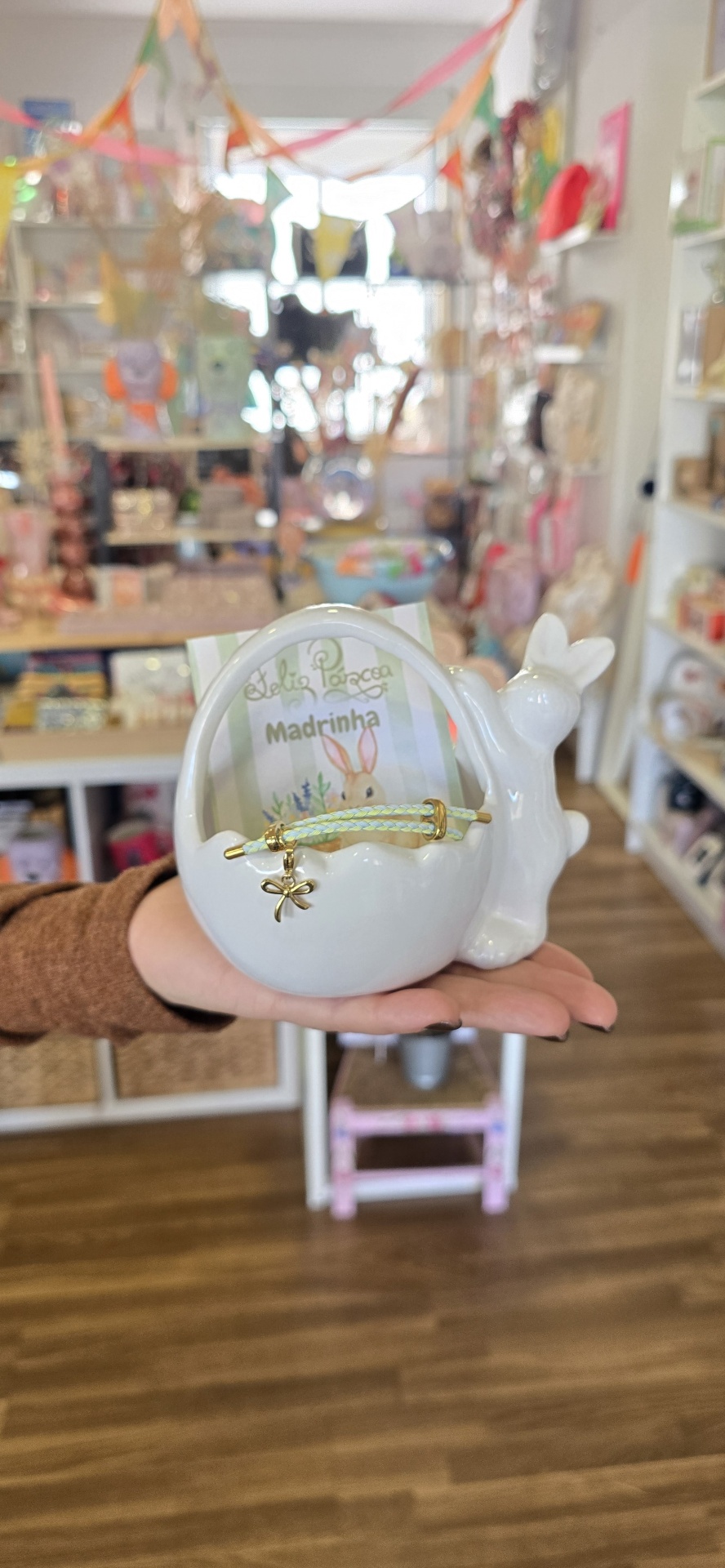 Cesta decorativa de cerâmica branca com coelho e cartão de páscoa em loja