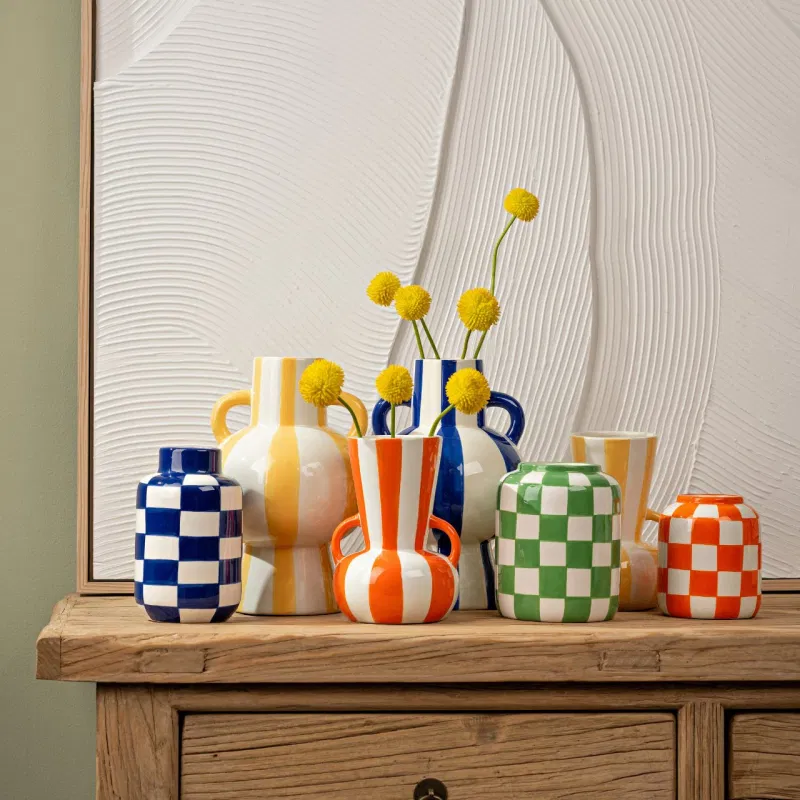 Oito jarros cerâmicos coloridos sobre mesa de madeira