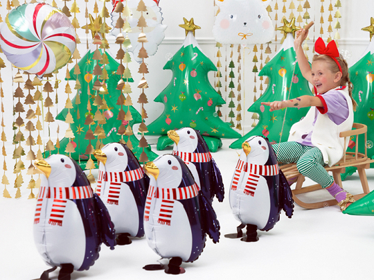 Conjunto de pinguins decorativos em material plástico com árvores de Natal infláveis e criança em trenó