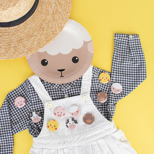 Roupa de criança com body xadrez, jardineiras brancas, botões com rostos de animais e chapéu de palha
