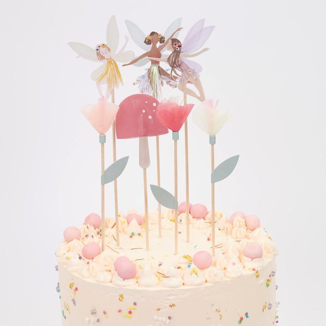 Bolo decorado com toppers de fadas e confeitos cor-de-rosa