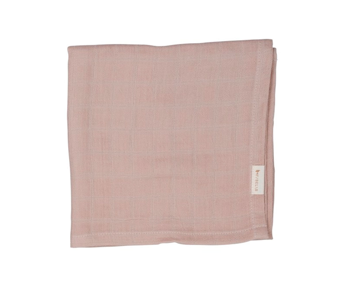 Manta ou toalha rosa claro com textura trançada e etiqueta.