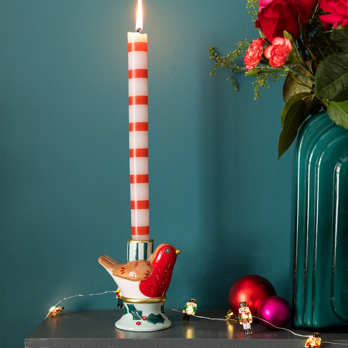 Castical decorativo em forma de pássaro com vela às riscas vermelhas e brancas