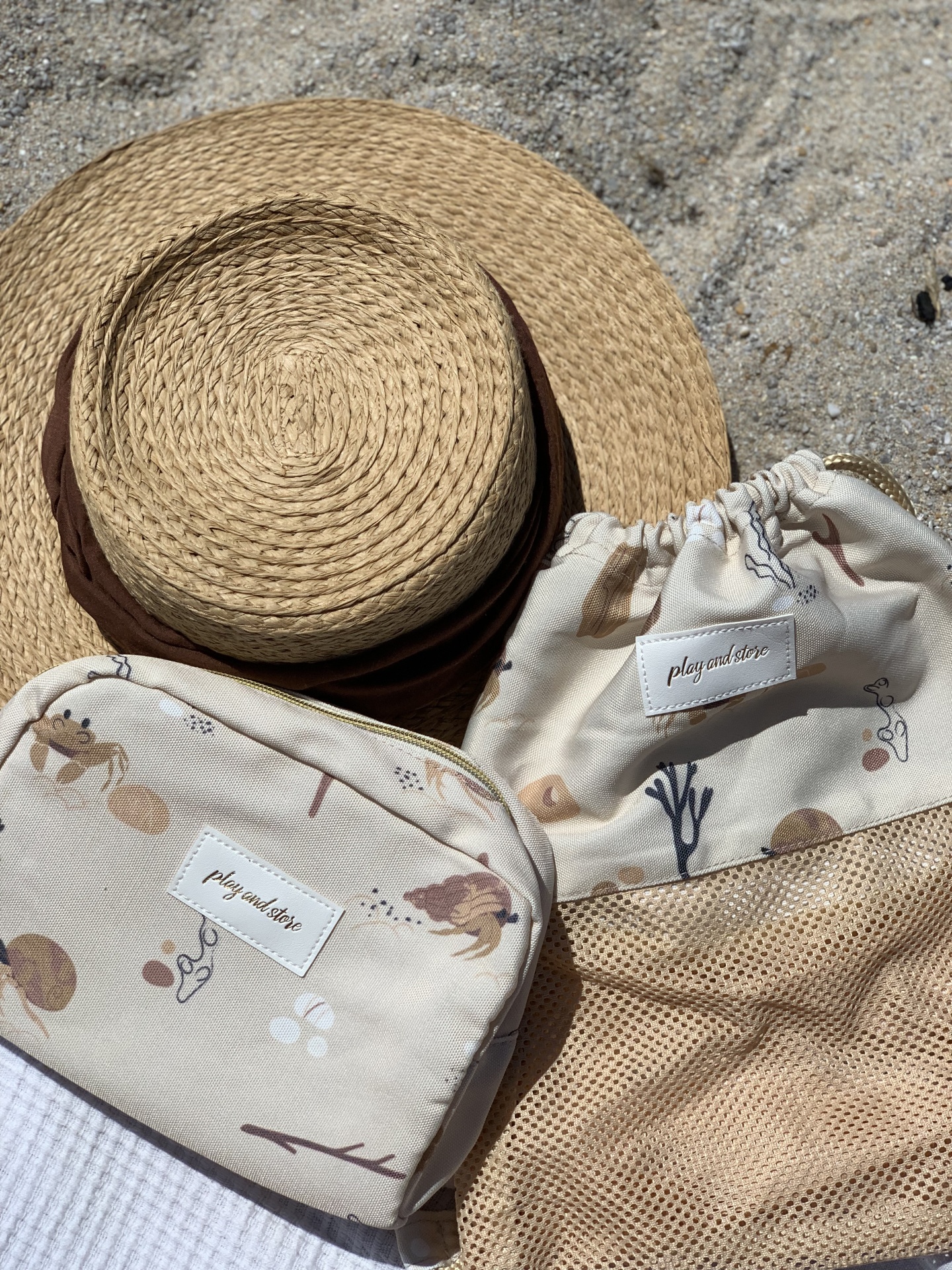 Chapéu de palha com duas bolsas de tecido estampadas em fundo neutro