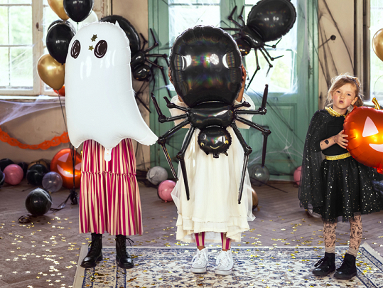 Crianças com balões de Halloween e fantasia em sala decorada