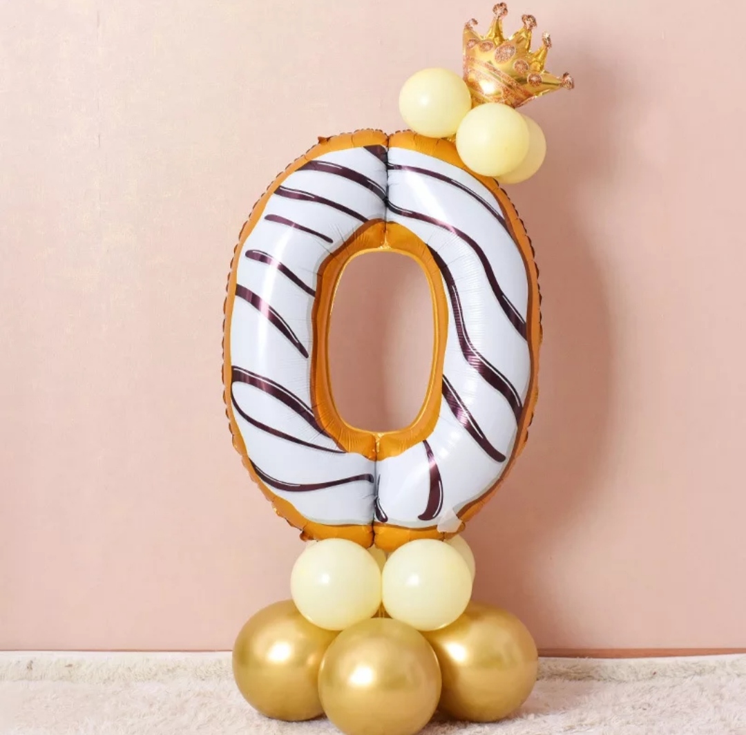 Balão em forma do número zero com detalhes dourados e base de balões dourados e creme