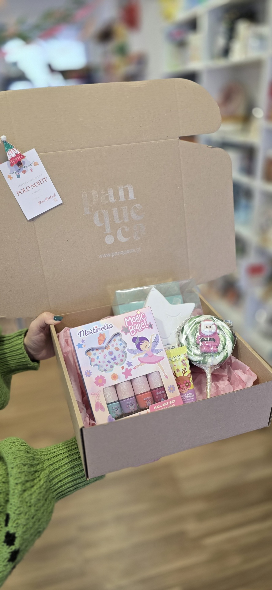 Caixa de cartão com produtos de beleza infantil e doces em fundo interior de loja