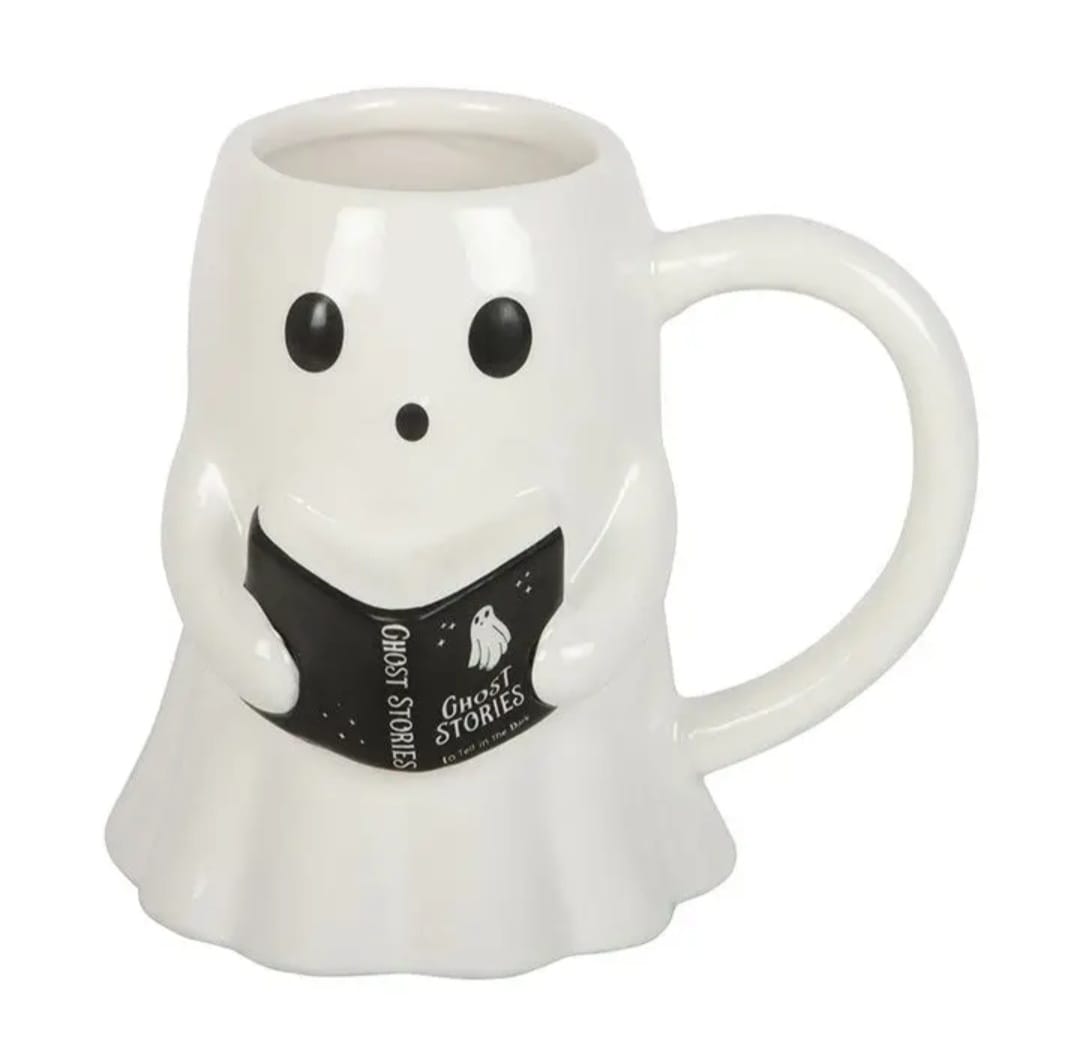 Caneca branca em forma de fantasma segurando livro preto com texto GHOST STORIES.