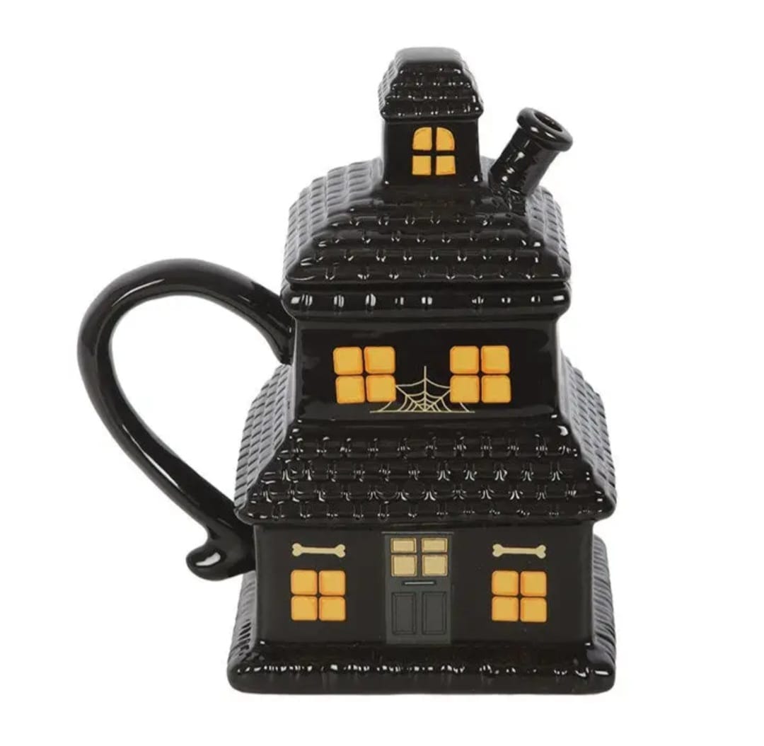 Caneca preta cerâmica em forma de casa assombrada com janelas amarelas