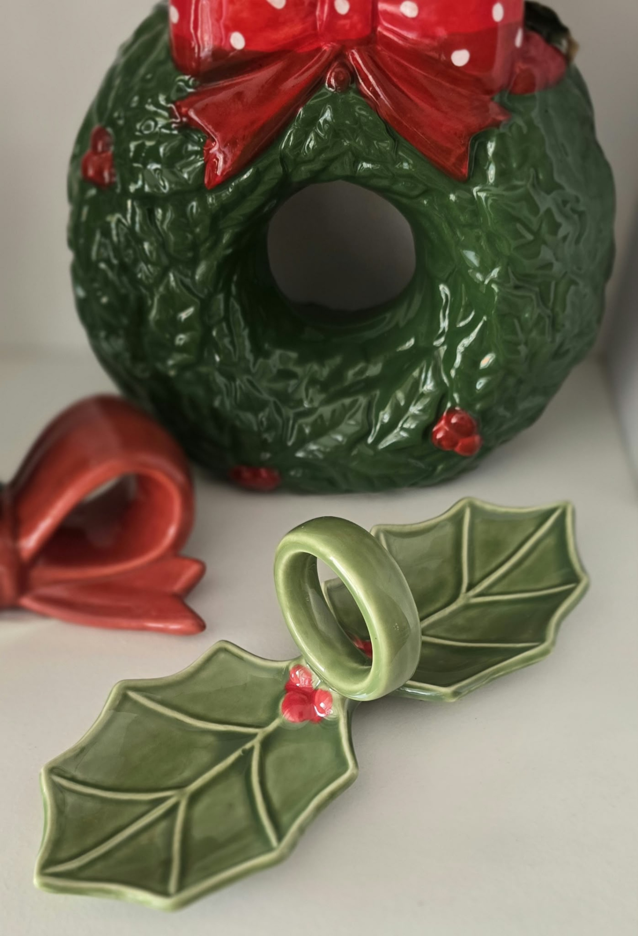 arranjo cerâmico festivo verde e vermelho com folhas, laços e bagas