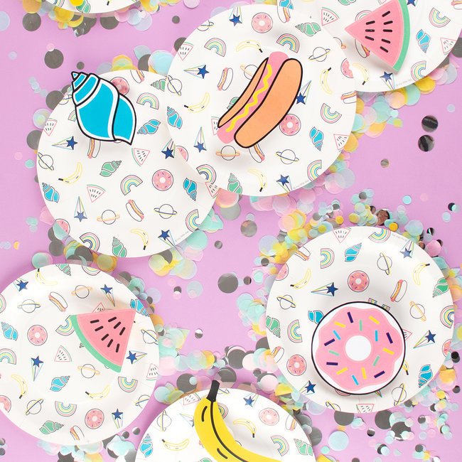 Pratos de papel com desenhos de caracol, cachorro-quente, melancia, banana e rosquinha em fundo rosa com confetes