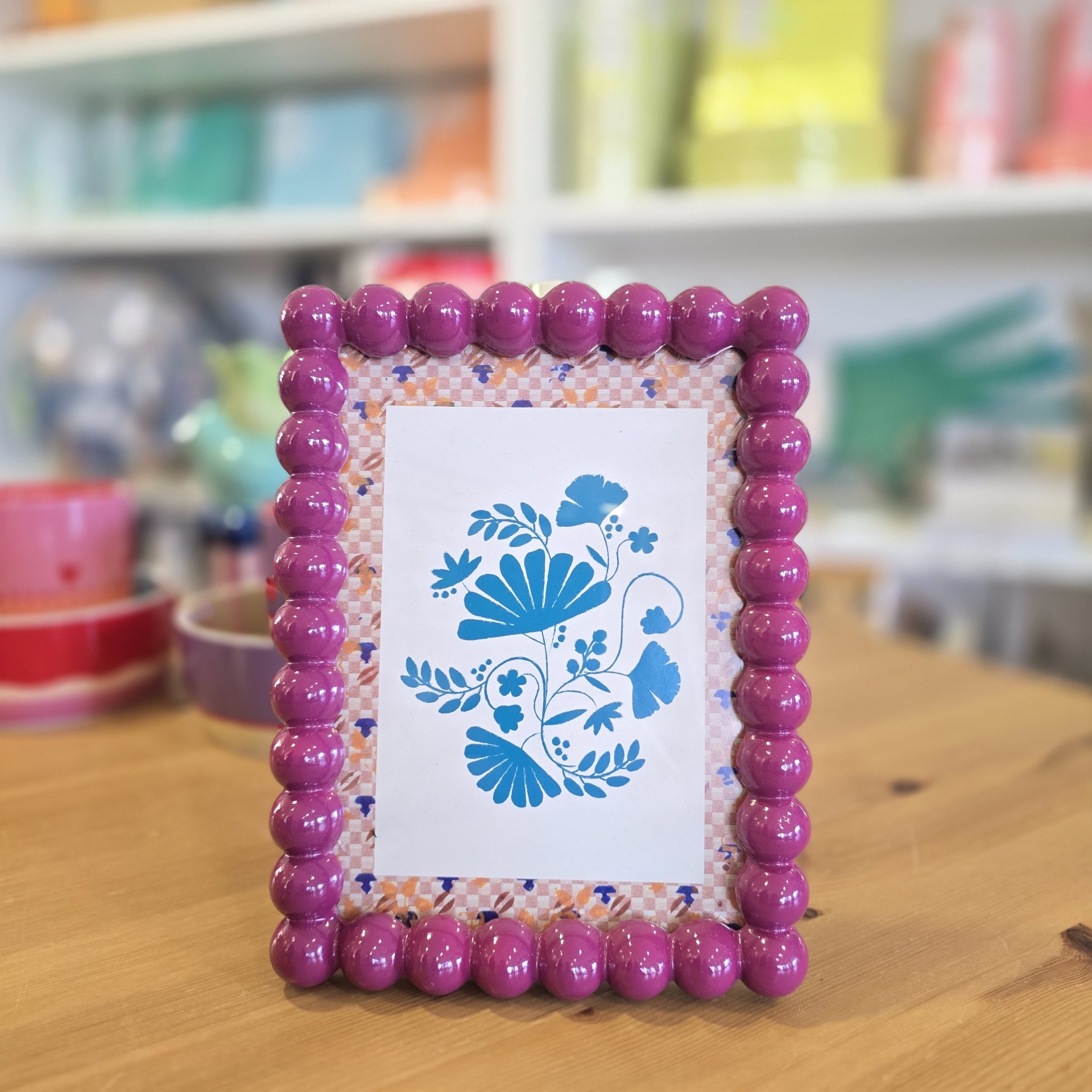 Moldura de fotografia rosa em madeira com decoração floral azul