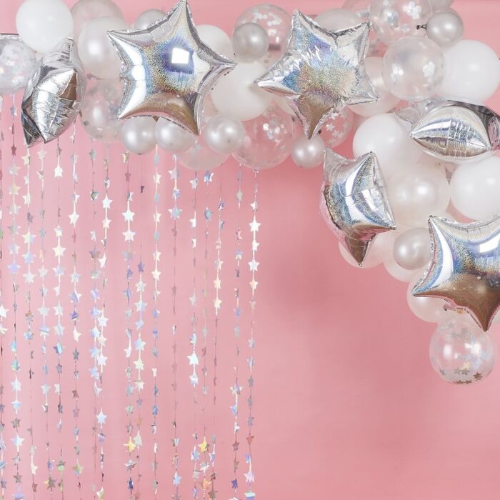 Arco de balões brancos, transparentes com confetes e estrelas prateadas com fundo rosa