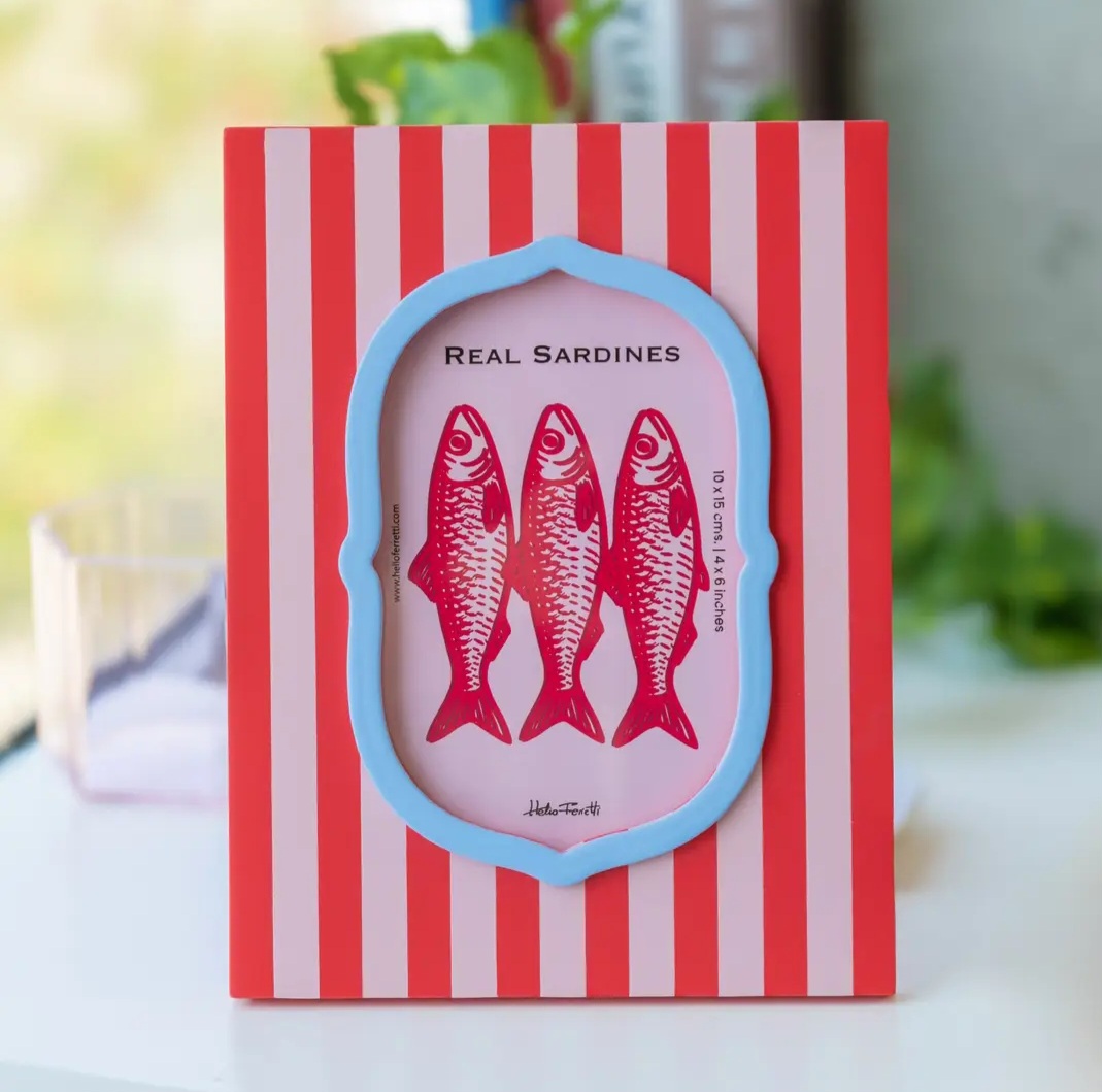 Moldura de fotografia vermelha com riscas brancas e borda azul, imagem de sardinhas vermelhas no centro.