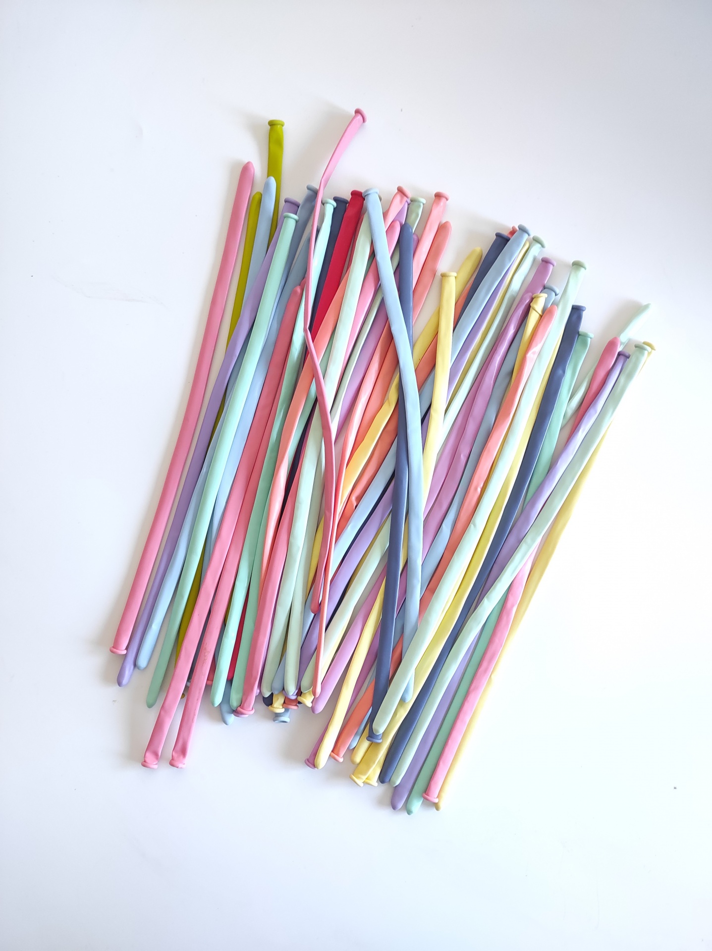 Varetas coloridas de plástico em tons pastel sobre fundo branco