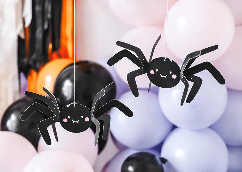 Duas aranhas decorativas pretas suspensas com balões coloridos ao fundo