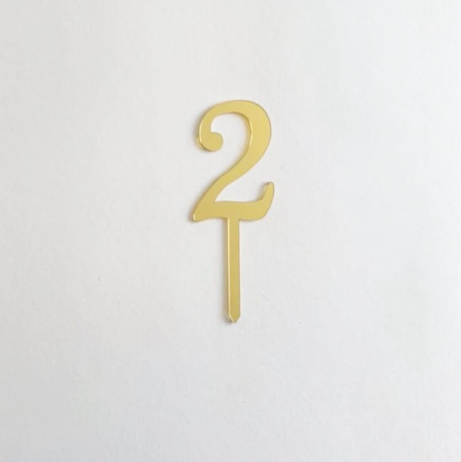 Número 2 dourado com suporte em fundo branco