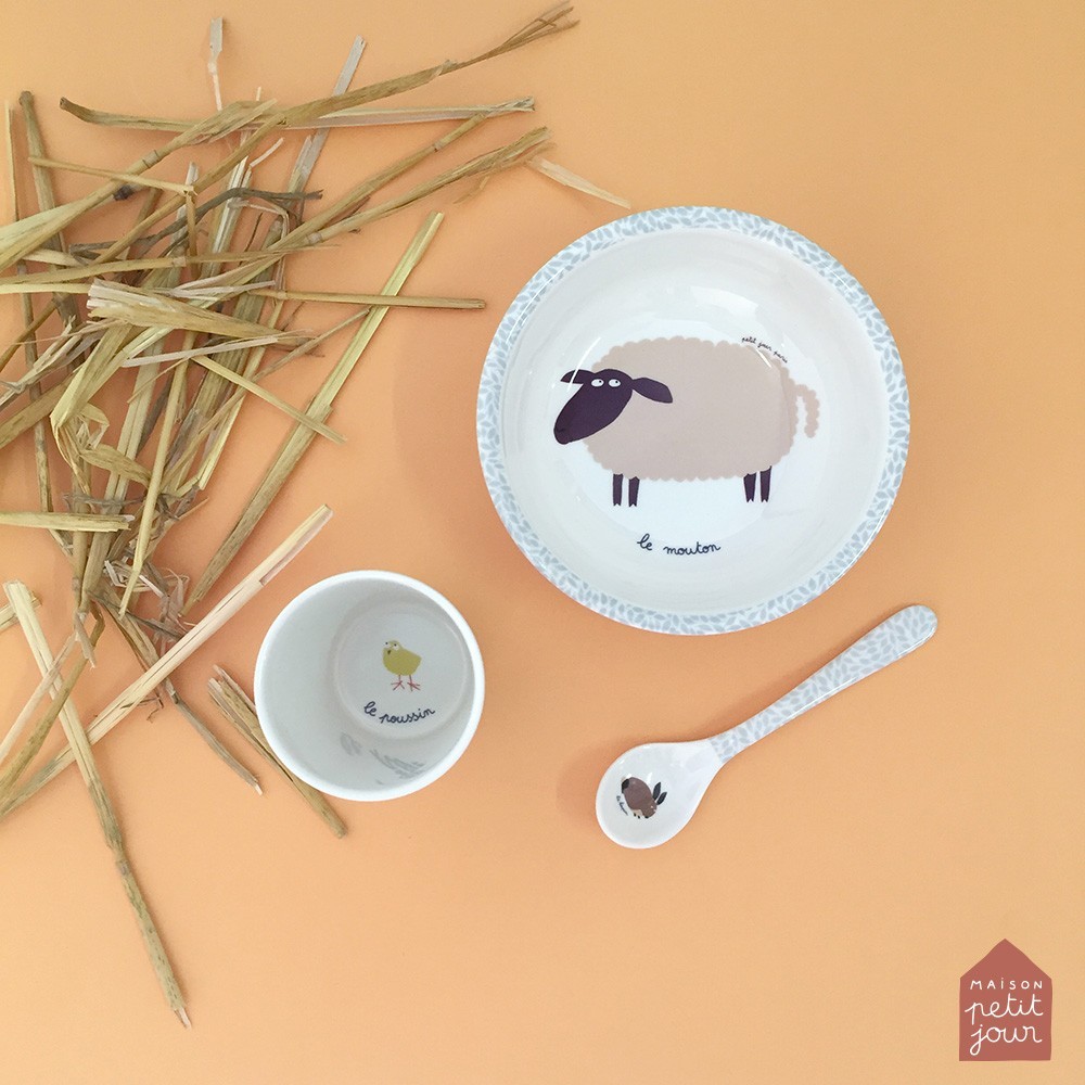 Conjunto de louça infantil com prato, tigela e colher decorados com animais e texto em francês