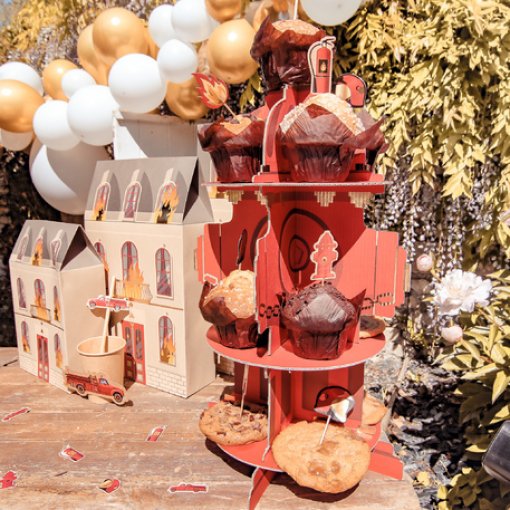 Expositor vermelho de bolinhos decorativo com bolachas e balões ao fundo