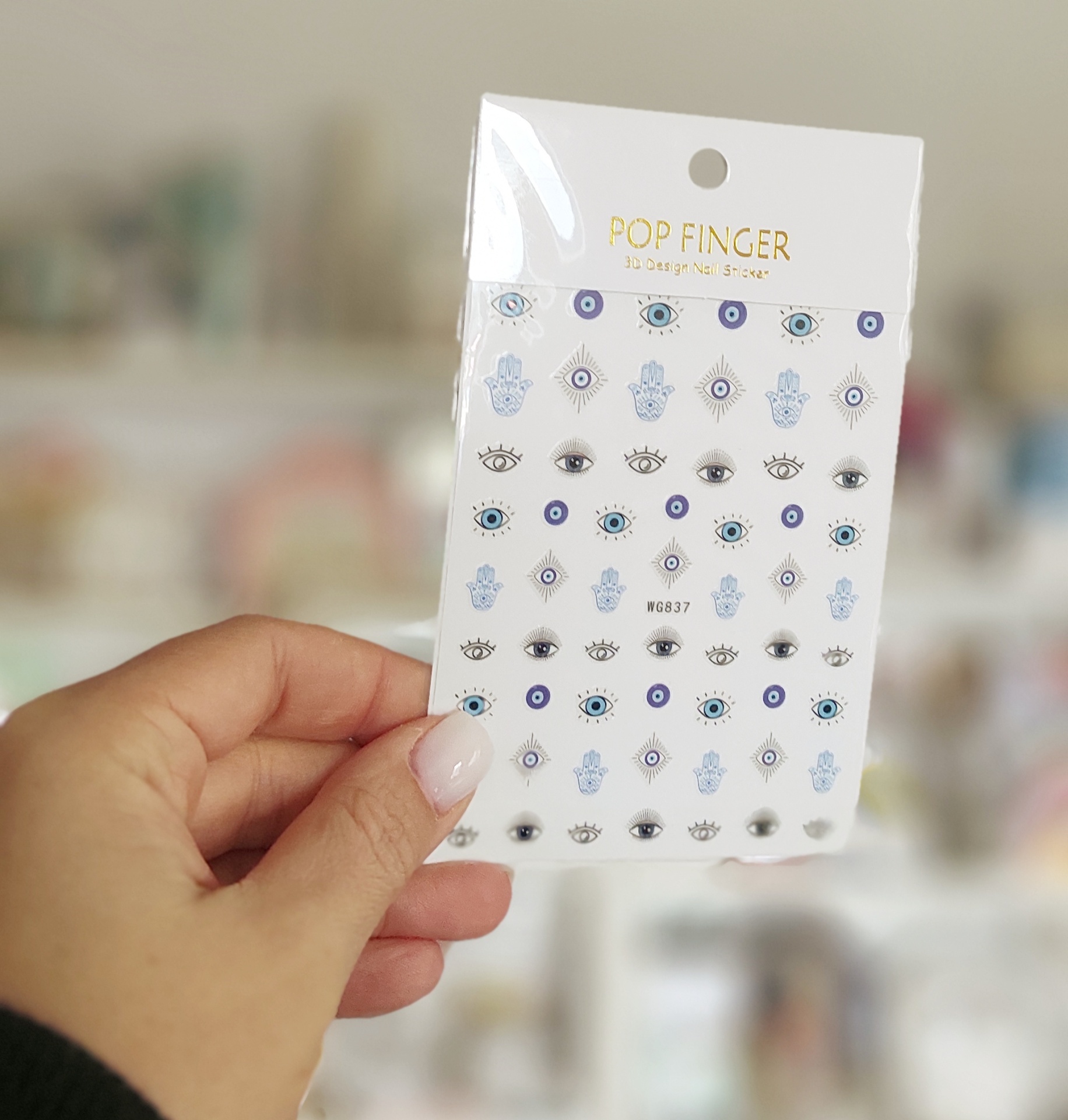 Cartela de stickers decorativos com vários desenhos de olhos e símbolos em cores azul, preto e branco.