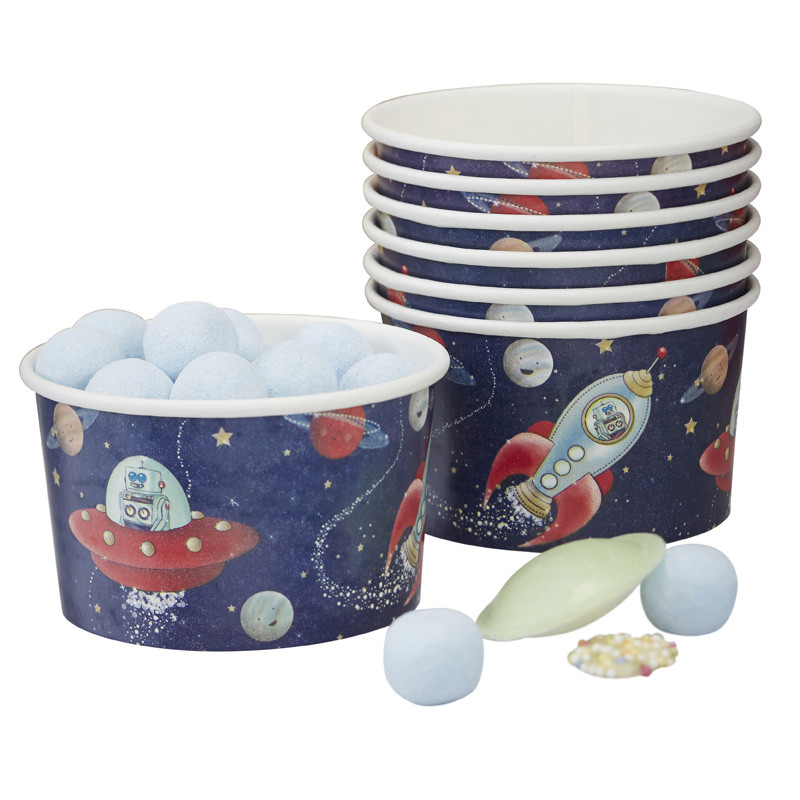 Copos de papel com padrão espacial e doces à volta.