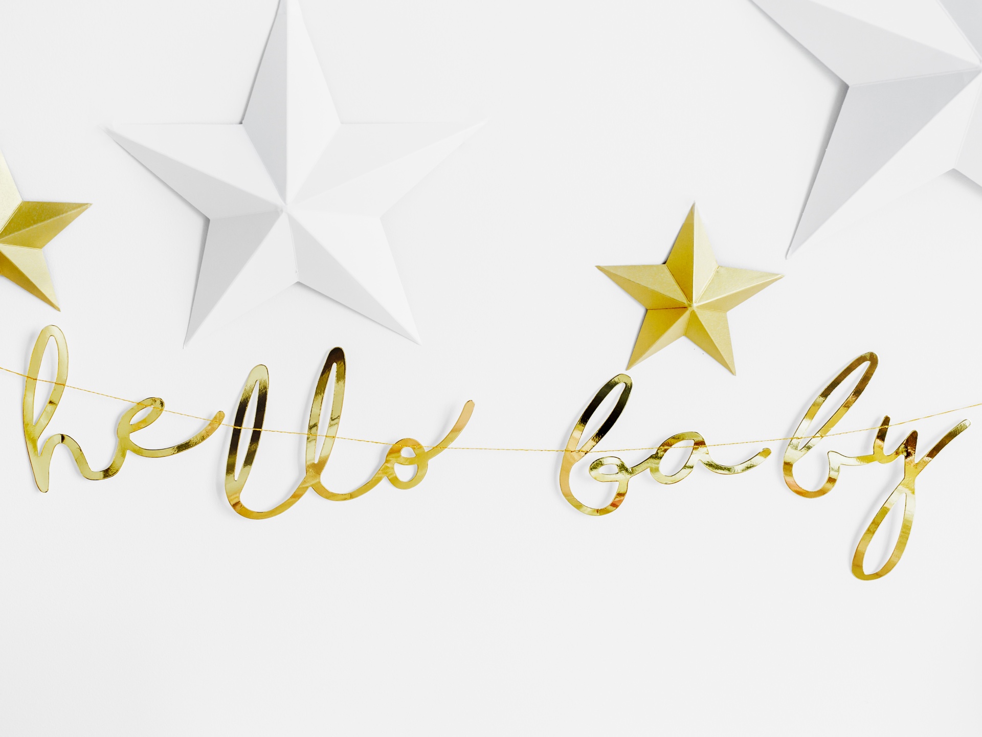 Decoração dourada com texto hello baby e estrelas brancas e douradas