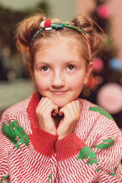 Criança com camisola de malha e fita de cabelo festiva