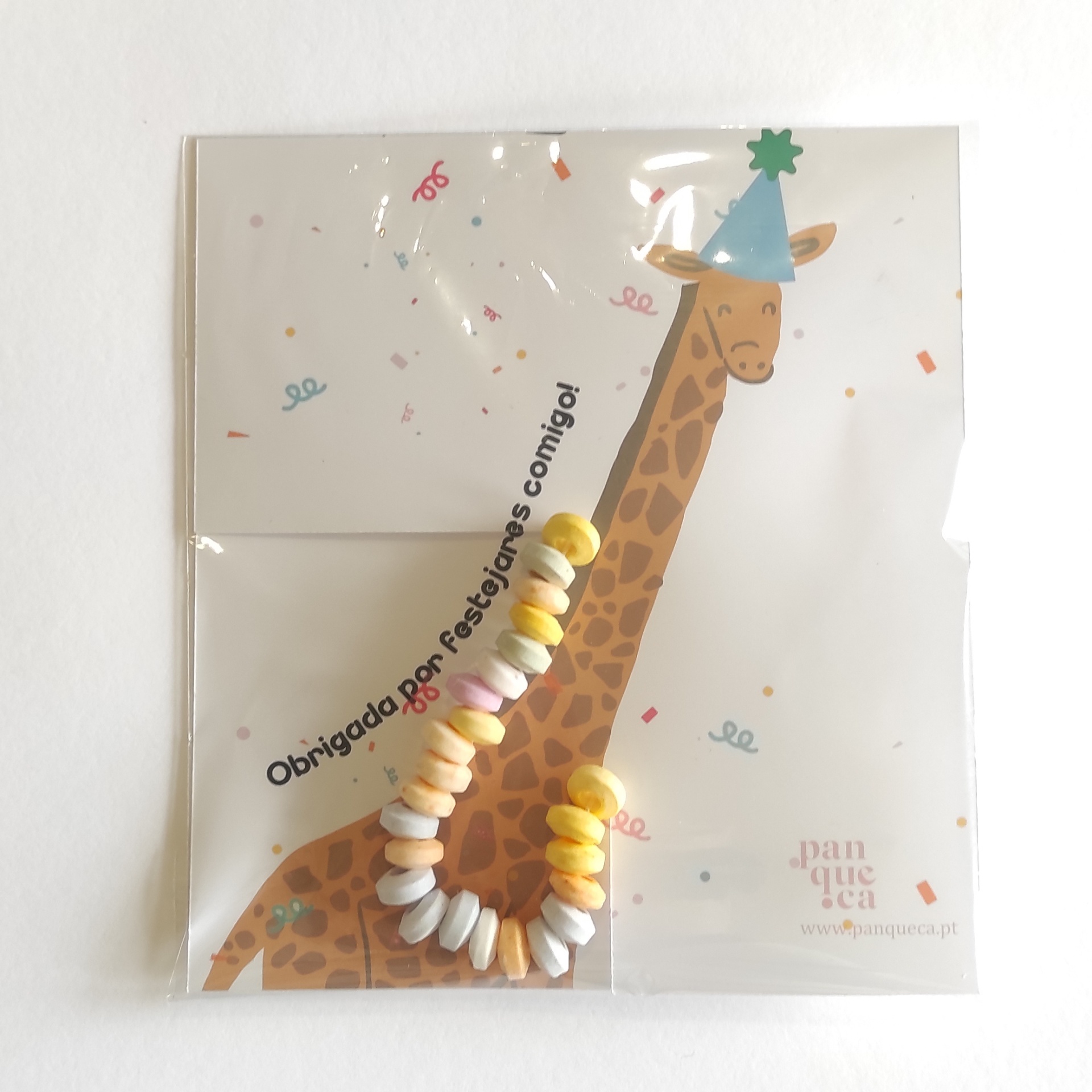 Pacote com desenho de girafa de festa e colar de doces coloridos.