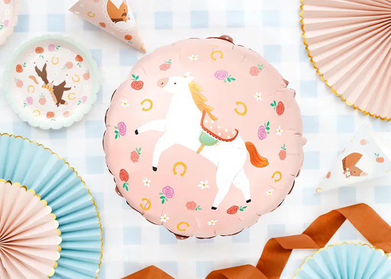 Balão rosa redondo decorado com cavalo branco e motivos florais rodeado de decoração em papel e fita laranja