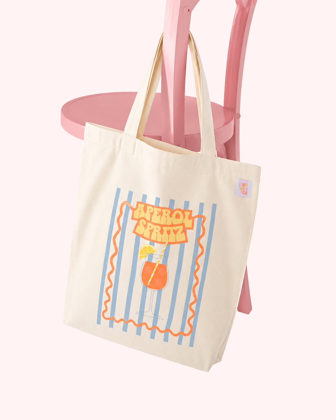 Saco de pano bege com design Aperol Spritz pendurado em cadeira rosa