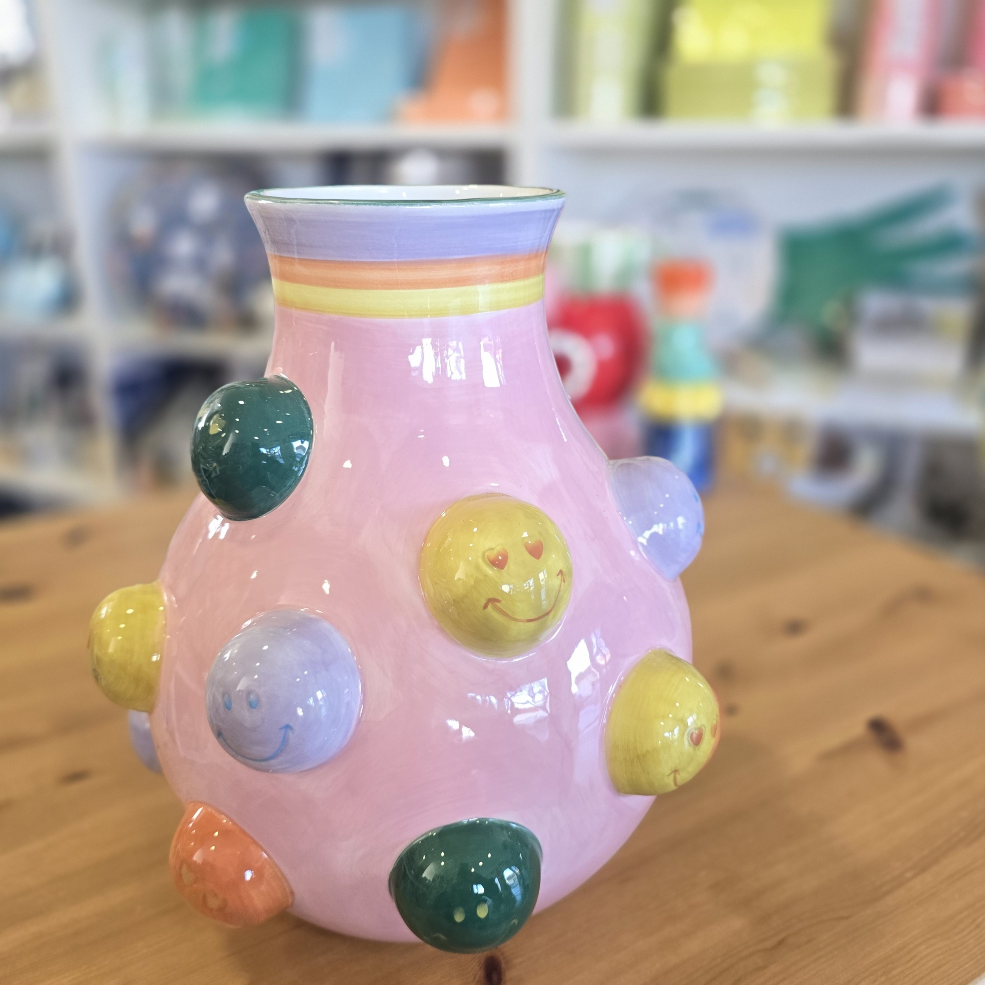 Vaso de cerâmica rosa com bolas salientes coloridas e carinhas sorridentes