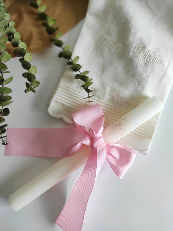 Velas brancas com fita rosa e pano branco bordado com texto