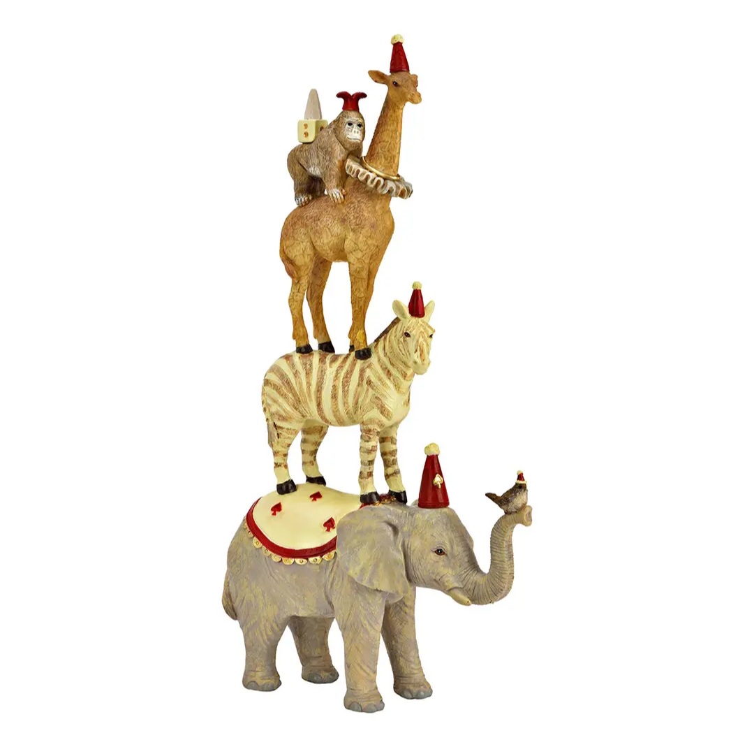 Escultura decorativa de quatro animais empilhados com chapéus vermelhos de festa.