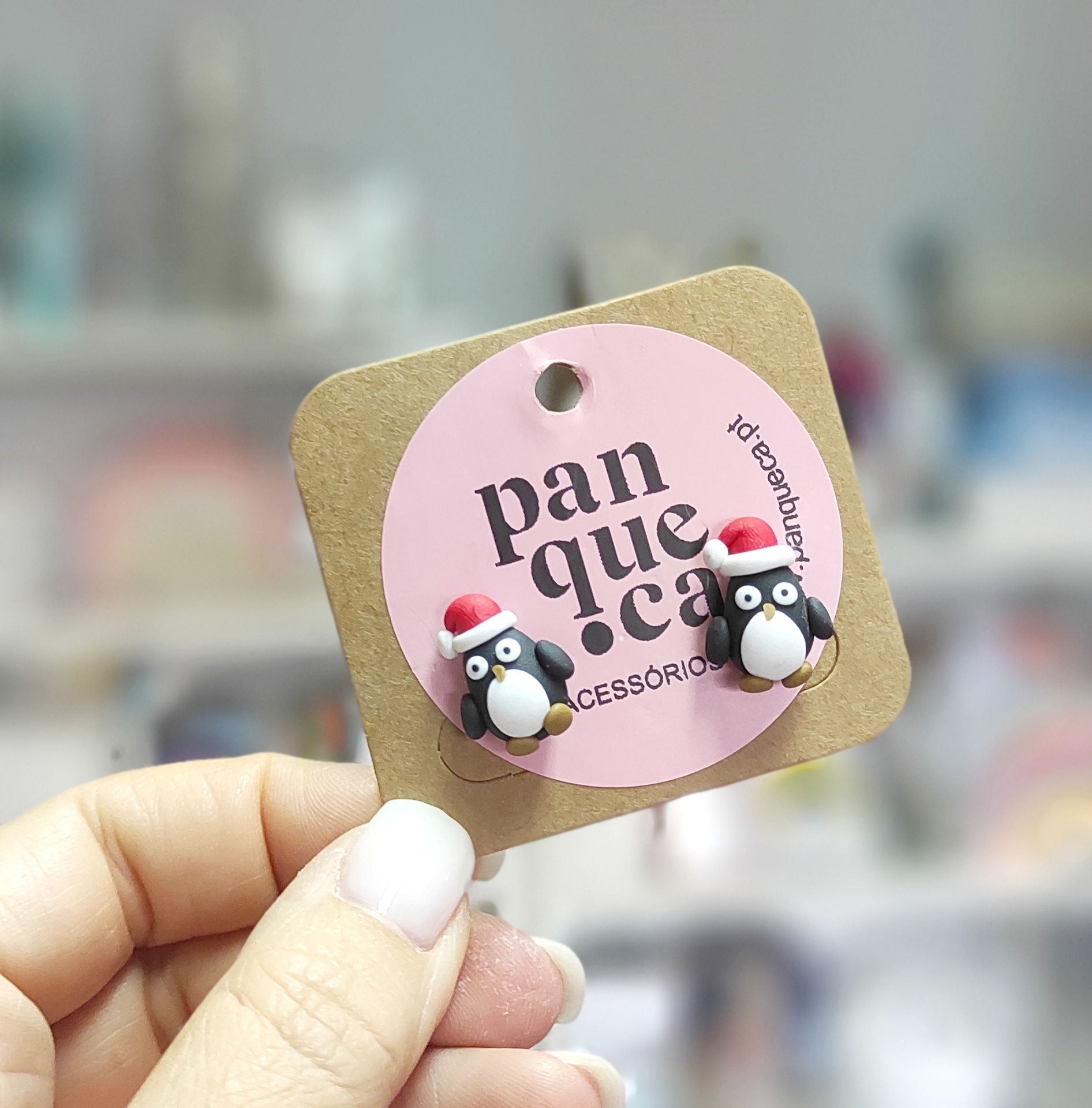 Brincos de pinguim de Natal pendurados em cartao