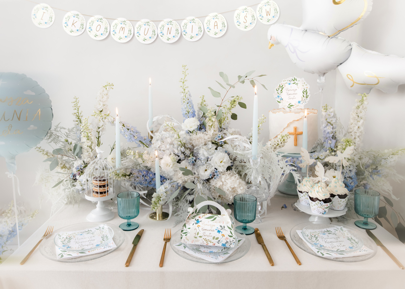 Mesa decorada para batizado com flores, velas e bolos