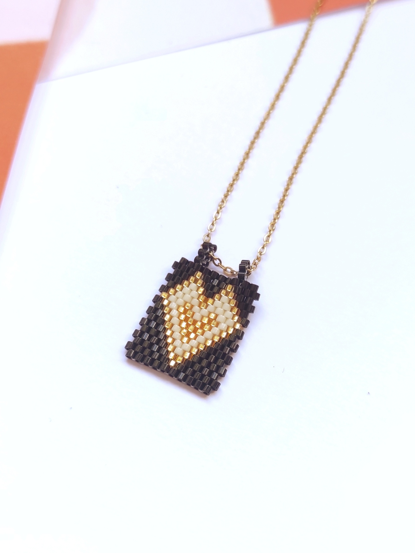 Colar com pingente retangular de contas com padrão de coração