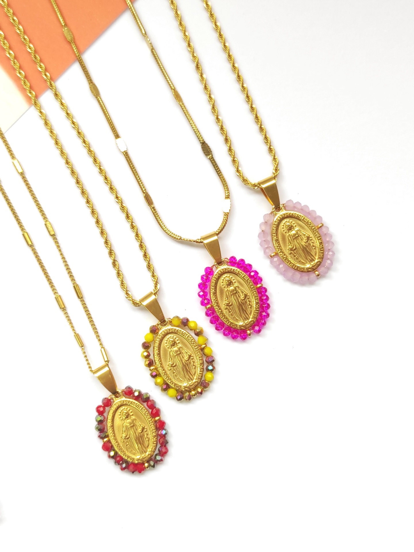 Quatro colares dourados com medalhões da Virgem Maria e pedras coloridas
