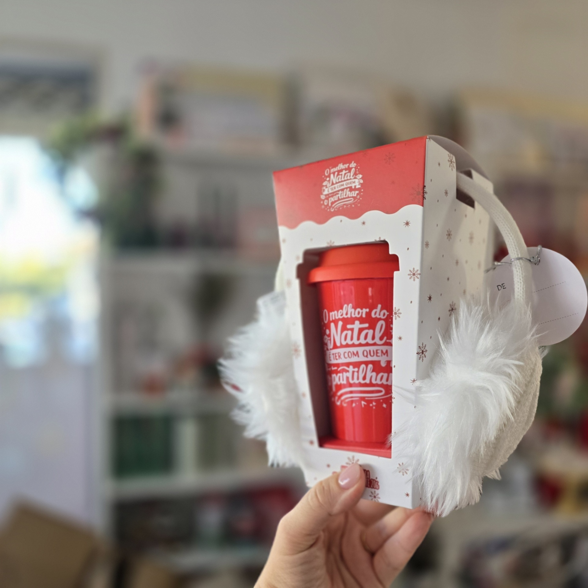 Embalagem de presente de Natal com caneca vermelha e mão com luva branca peluda