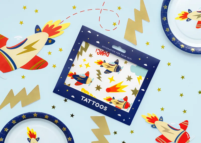 Tatuagens temporárias com desenhos de aviões a jato e estrelas numa embalagem azul