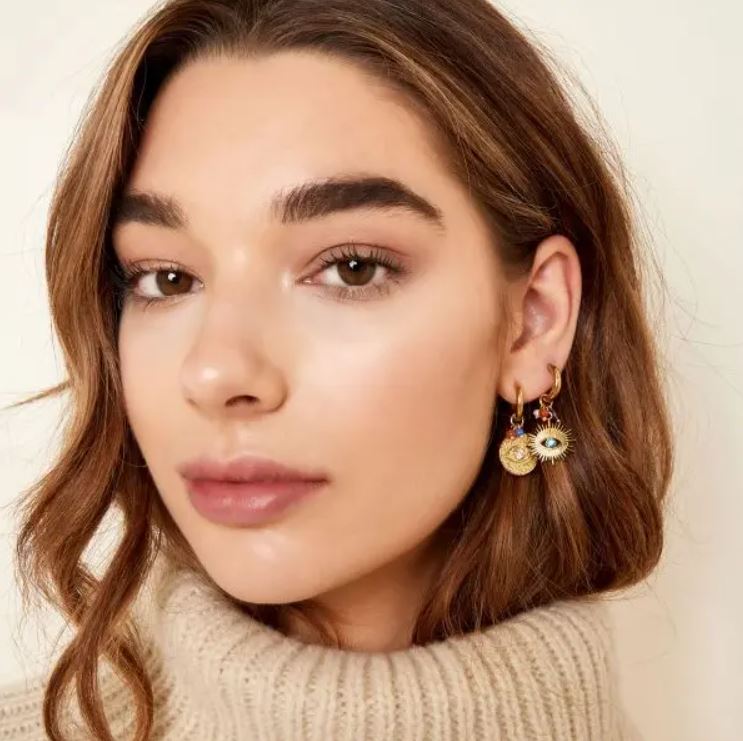 Brincos dourados com pendentes de olhos em argola