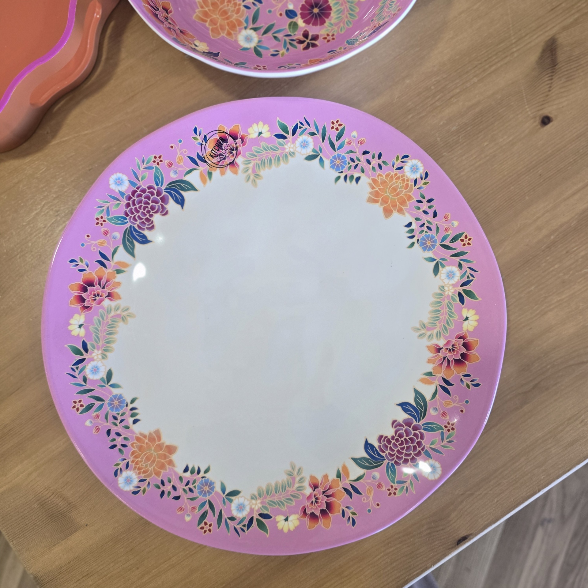 Prato redondo de cerâmica com borda rosa e flores coloridas