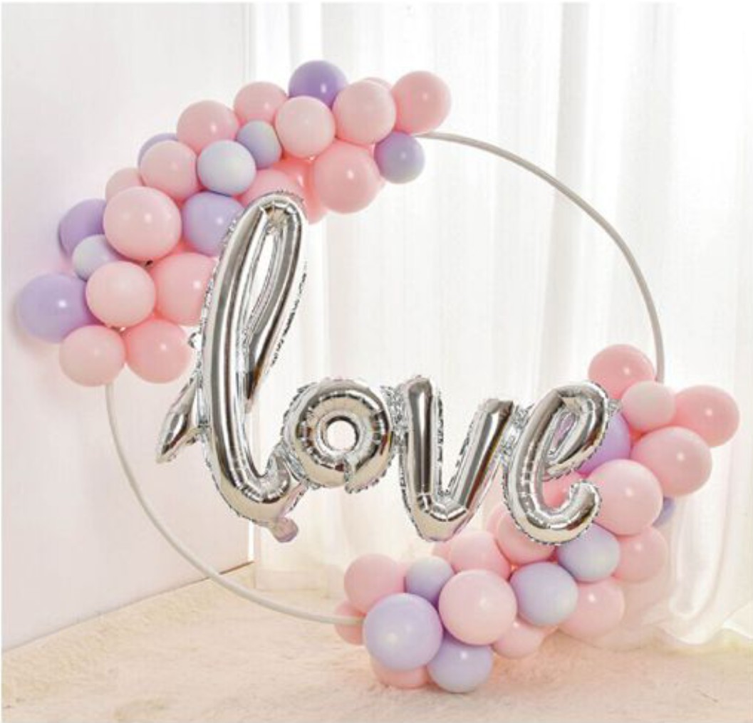 Arco decorativo redondo com balões rosa, lilás e palavra love em prateado