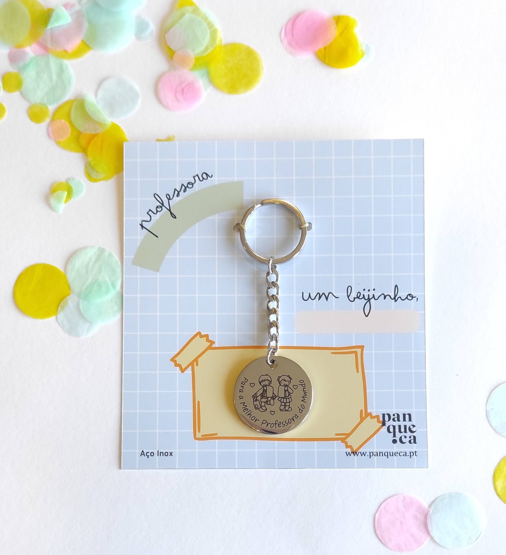 Chaveiro redondo em aço inox com ilustração, em cartão azul com padrão de grelha e texto relacionado a professoras.