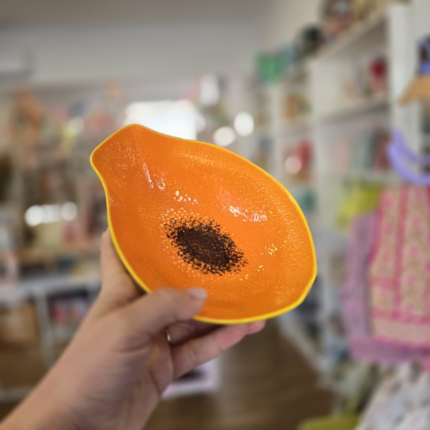 Prato decorativo em forma de papaia com cores laranja, preto e amarelo