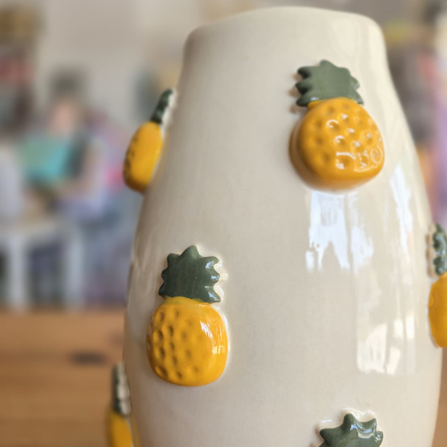 Vaso cerâmico bege com abacaxis em alto relevo