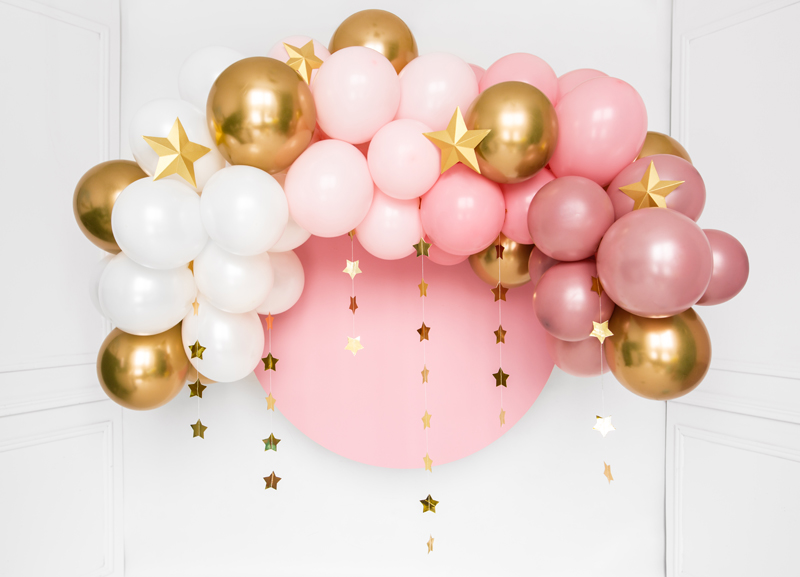 Arco decorativo de balões rosa, branco e dourado com estrelas penduradas