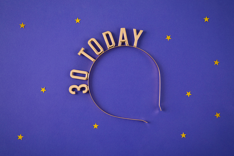 Tiara dourada com texto '30 TODAY' em fundo roxo com estrelas amarelas