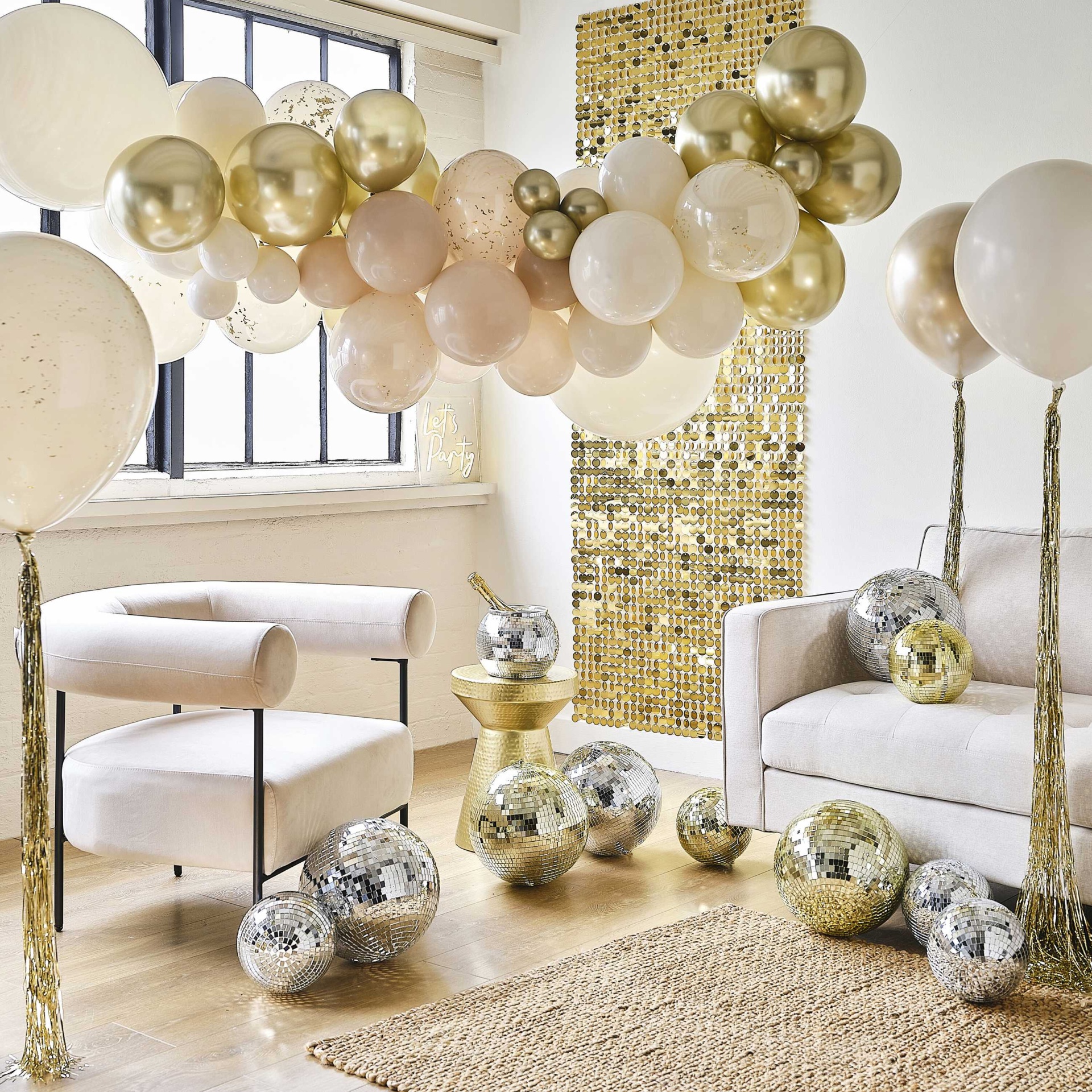 decoração interior com balões dourados e bege, poltronas creme e mosaico dourado