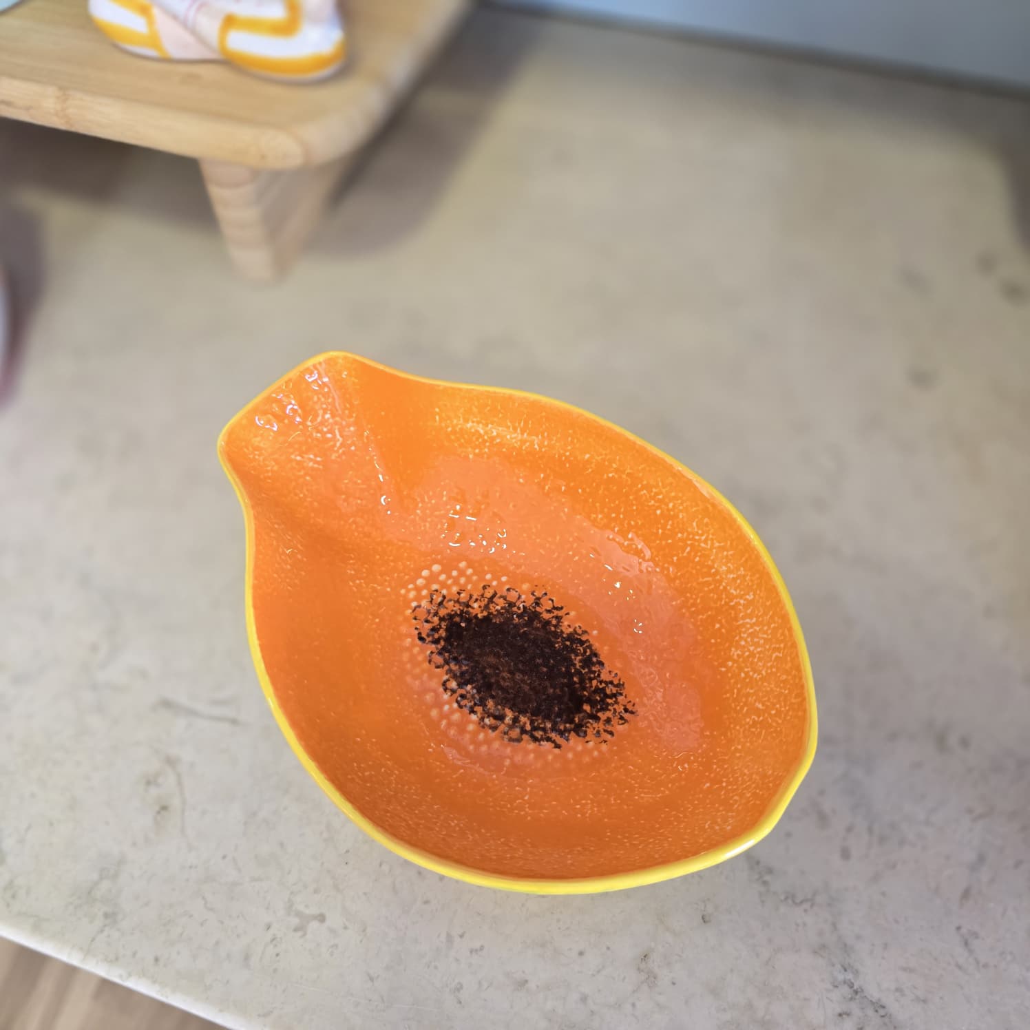 Taça de cerâmica laranja brilhante com padrão castanho no centro